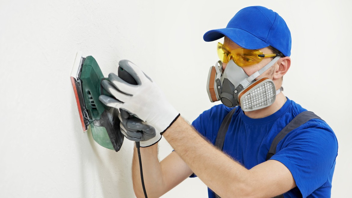 photodune-3980978-worker-with-orbital-sander-at-wall-filling-m